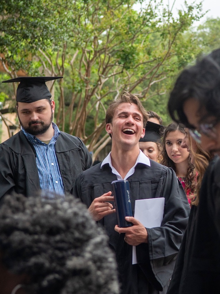 Students in caps and gowns smiling